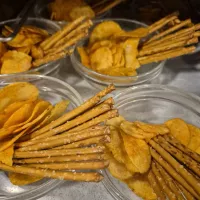 Fünf Schüsseln mit Chips und Salzstangen